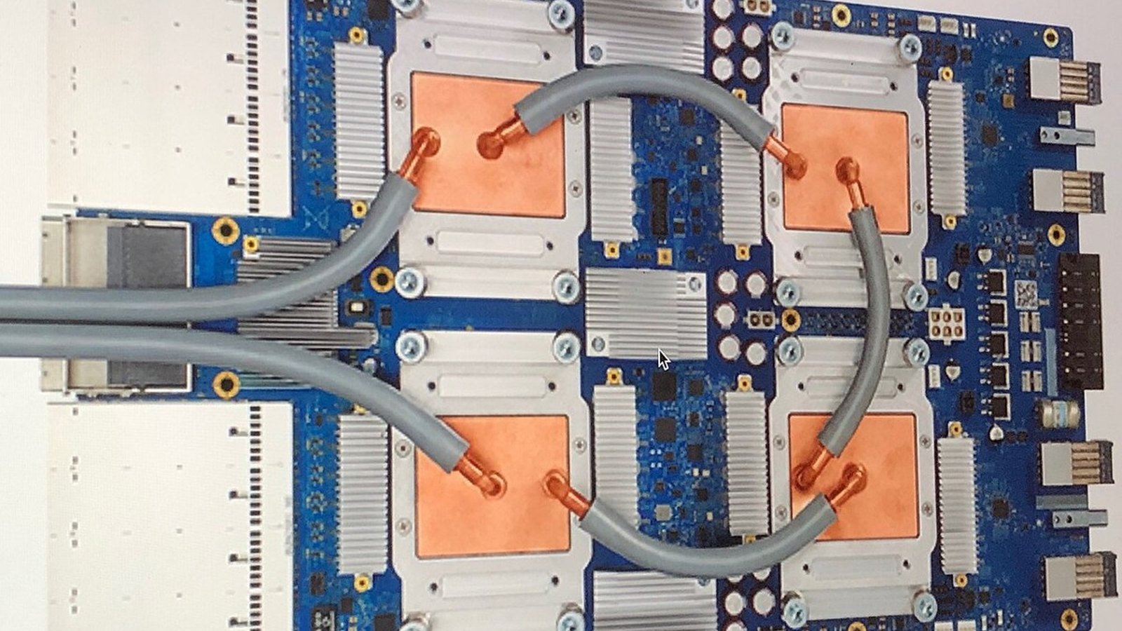 Close-up of an AI accelerator chip with a gold heat spreader on a black circuit board