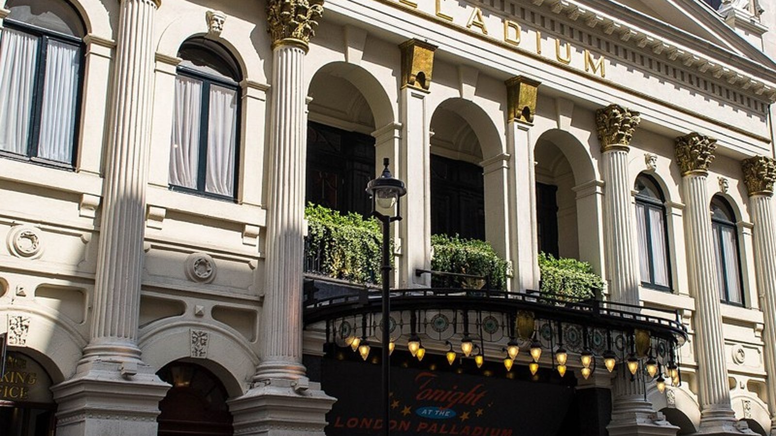 The red and gold auditorium and stage of the London Palladium theatre lit by spotlights