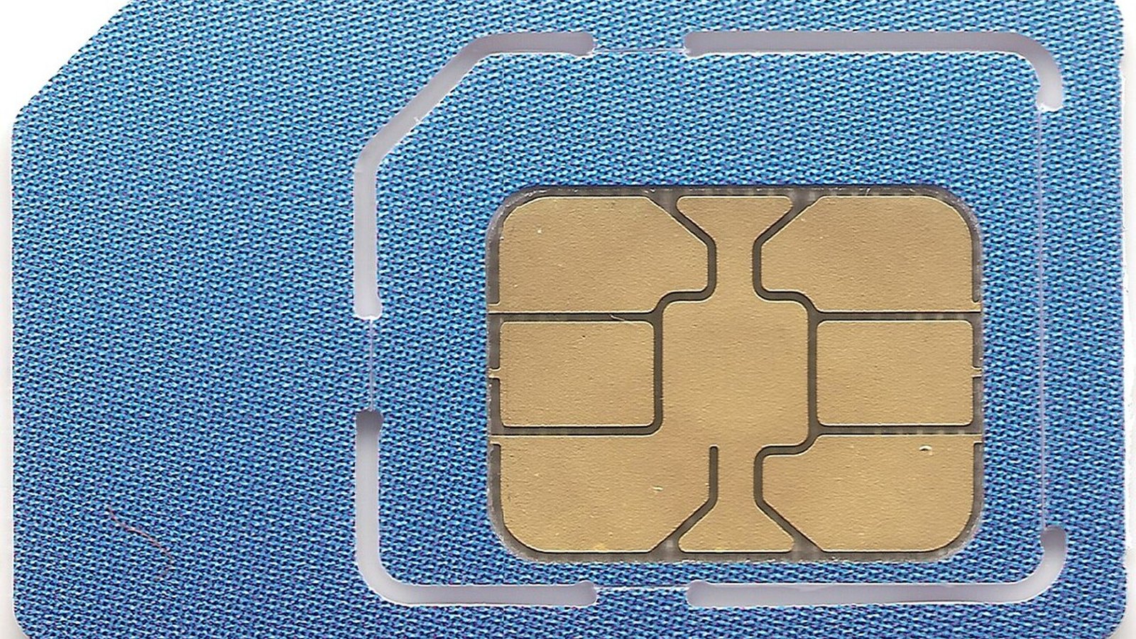 A smartphone with an incoming call screen beside a SIM card on a dark surface