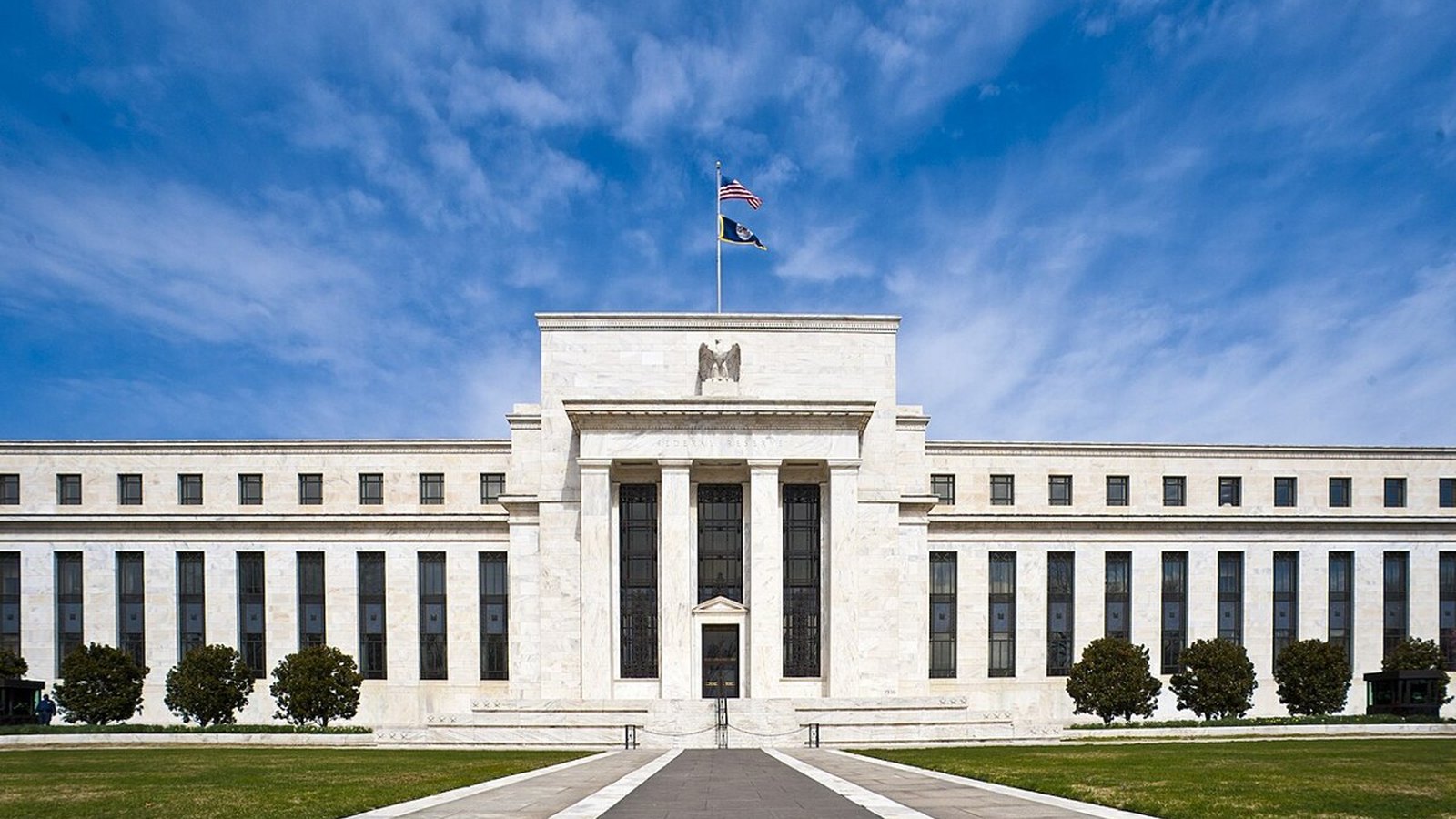 Marble facade of the Federal Reserve Board building in Washington under a clear blue sky